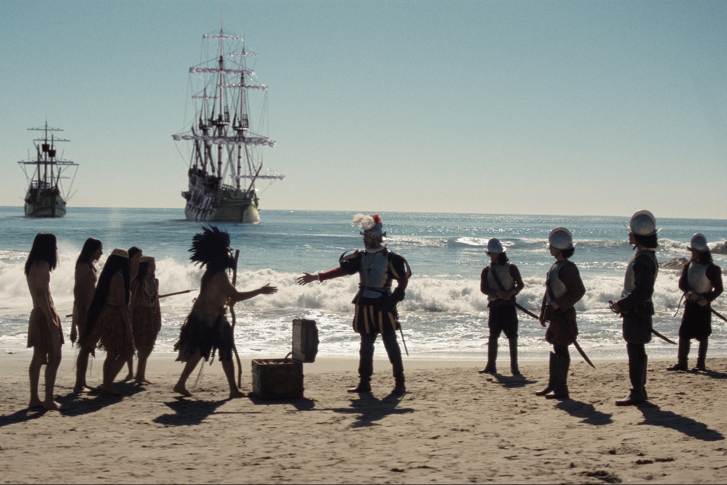 Reenactment of Kumeyaay people standing on a San Diego beach with Spanish ships from the Cabrillo expedition visible in the ocean behind them in 1542.